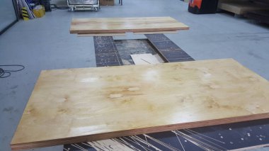 Marangozluk atölyesindeki bir masanın üzerine henüz tamamlanmamış iki tahta parçası yerleştirildi.