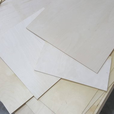 İnce, tamamlanmamış ahşap paneller düzgün istiflenmiş, doğal tahıl desenlerini ve açık sarı tonlarını sergiliyorlar, DIY uygulamaları için mükemmel.