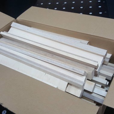 Bir projede kullanılmaya hazır sayısız istiflenmiş tahta ve daha küçük inşaat parçalarının bulunduğu karton bir kutunun yakın plan görüntüsü