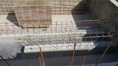 Güneşli bir günde beton dökmek için hazırlanmış tuğlaları ve çelik parmaklıkları olan güçlendirilmiş beton yapı.