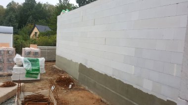 İnşaatın ilk aşamalarını gösteren beton bloklar ve inşaat demirleriyle yeni bir ev inşa ediliyor.