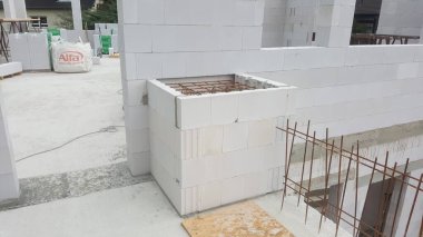 Duvarlar için yığılmış hafif beton bloklar ve beton dökülmeye hazır takviye çubukları içeren tamamlanmamış dış yapı