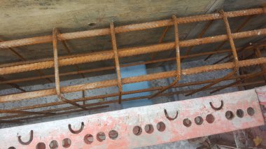 Çelik takviye çubukları ve beton döşeme hazırlıklarının yakın görüntüsü, altyapı inşaatında kullanılan inşaat ilerlemelerini ve materyalleri gösteriyor