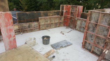 Çelik takviye çubukları ve inşaat malzemelerini gösteren yeni bir yapı için beton biçimlendirme sistemi kuruldu.