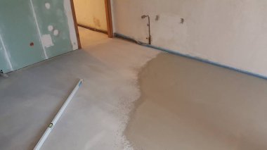 Bir inşaat sahası taze beton zeminin doldurulduğunu ve pürüzsüzleştirildiğini gösteriyor. Ruhsal düzlüğü de düz olduğunu gösteriyor.