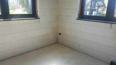 Beton zemin ve havalandırmalı beton blok duvarları olan yeni bir binada tamamlanmamış bir oda. İç dekorasyona hazır.