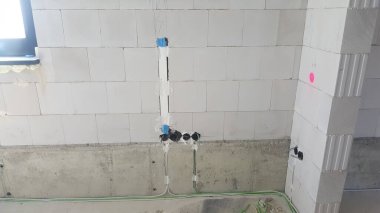 Görünür elektrik hatları ve bağlantı kutuları hafif beton bloklardan yapılmış bir duvara monte edilir ve zemin boyunca görünen kablolar çalışır.