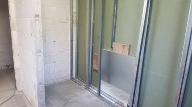 İnşaat halindeki bir binanın içini görmek, duvarların iskeletini ve alçıpan kurulumunun ilk aşamalarını vurgulamak