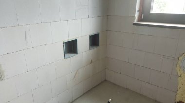 İnşaat halindeki binanın iç manzarası, havalandırmalı beton duvarlar ve iki kare elektrik tesisatı için hazır.