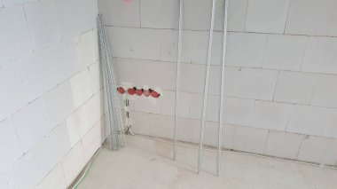 Tamamlanmamış iç mekan tuğla duvarlar, elektrik kutuları ve metal çerçeve elementleri alçıpan için hazır.