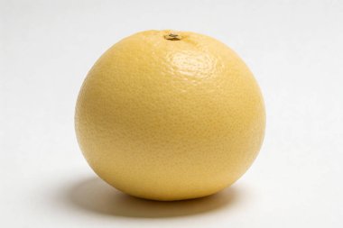 Bu yakın çekim stüdyo çekiminde, tamamen olgun, sarı bir greyfurt ve kabuklu, azami görsel etki için katıksız beyaz bir zemin sunuluyor.