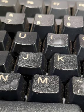 a closeup shot of an old keyboard with a black key