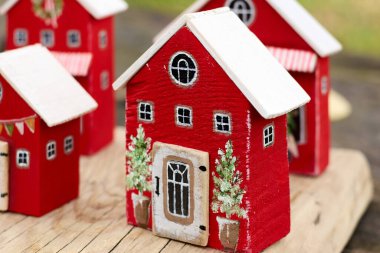 Tatil temalı süslemeleri, minyatür saksı ağaçlarını, ahşap tahtalara kurulmuş sıcak bir Noel köyü ruhunu anımsatan el yapımı kırmızı ahşap evler..