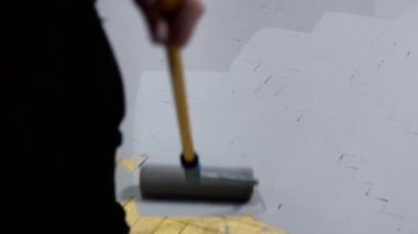 Zeminin paten boyası, insan evi yenilemek ve yenilemek için ahşap zemini gri boyayla kaplar. Boya, yenileme ve onarım konseptiyle döşemenin iyileştirilmesi..