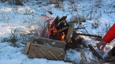 Kırsal ahşap elementlerle çevrili, kış karları arasında alevli bir kamp ateşi çıtırdıyor. Sıcaklık, hayatta kalma ve kış kamplarının dingin atmosferini yaratıyor. Dışarıdaki soğuk havayla ateşin davetkar parıltısını zıtlaştırıyor..