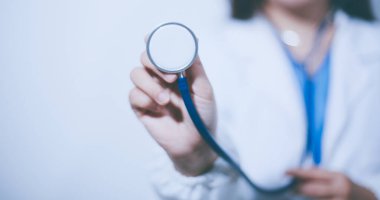 Elinde steteskop tutan genç bir erkek doktor.