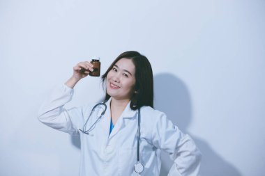 Tedavi için ilaç ya da ilaç tutan doktor ya da eczacı. Şişede antibiyotik hap var..