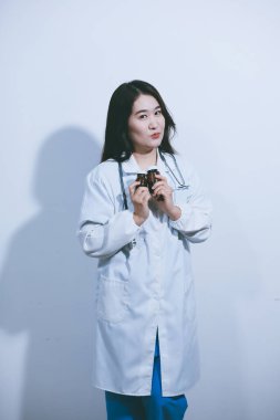 Tedavi için ilaç ya da ilaç tutan doktor ya da eczacı. Şişede antibiyotik hap var..