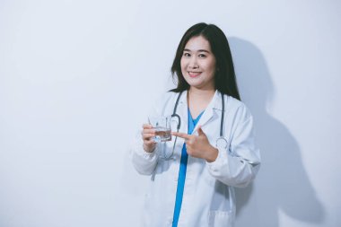 Beyaz stüdyo arka planında elinde kahve fincanı tutan Asyalı kadın portresi.