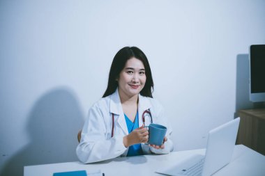 Laboratuvarda kahve fincanı tutan kadın bilim adamı.