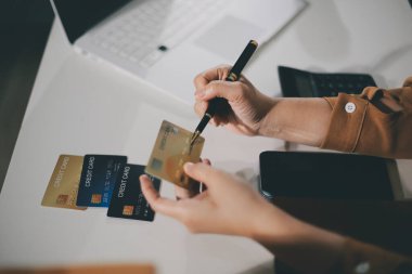 Çevrimiçi ödeme, kredi kartı tutan ve online alışveriş için akıllı telefon kullanan kadının elleri.