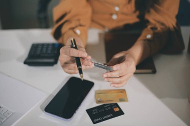 Çevrimiçi ödeme, kredi kartı tutan ve online alışveriş için akıllı telefon kullanan kadının elleri.