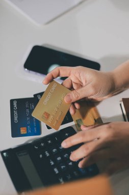 Çevrimiçi ödeme, kredi kartı tutan ve online alışveriş için akıllı telefon kullanan kadının elleri.