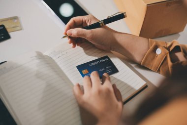 Çevrimiçi ödeme, kredi kartı tutan ve online alışveriş için akıllı telefon kullanan kadının elleri.