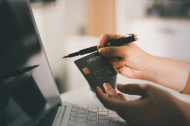 Çevrimiçi ödeme, kredi kartı tutan ve online alışveriş için akıllı telefon kullanan kadının elleri.