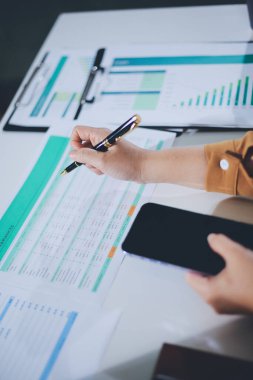 Business woman using calculator to calculate financial report, working at office with laptop computer on table. Asian female accountant or banker making calculations. finances and economy concept