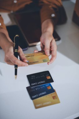 Çevrimiçi ödeme, kredi kartı tutan ve online alışveriş için akıllı telefon kullanan kadının elleri.