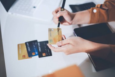 Çevrimiçi ödeme, kredi kartı tutan ve online alışveriş için akıllı telefon kullanan kadının elleri.