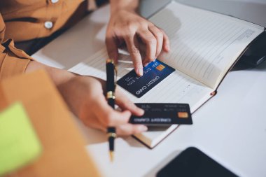 Çevrimiçi ödeme, kredi kartı tutan ve online alışveriş için akıllı telefon kullanan kadının elleri.