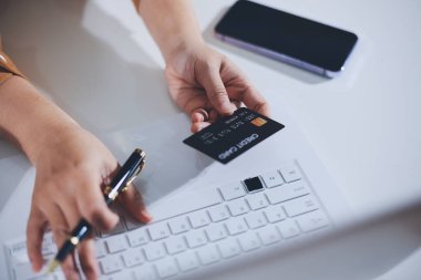 Çevrimiçi ödeme, kredi kartı tutan ve online alışveriş için akıllı telefon kullanan kadının elleri.