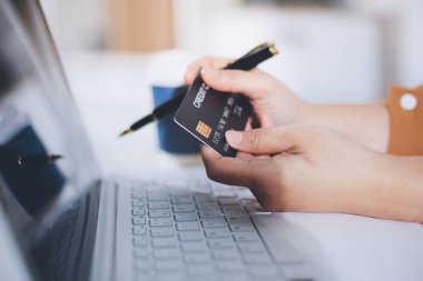 Çevrimiçi ödeme, kredi kartı tutan ve online alışveriş için akıllı telefon kullanan kadının elleri.