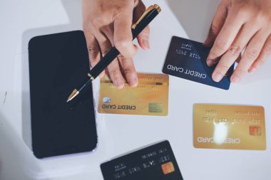 Çevrimiçi ödeme, kredi kartı tutan ve online alışveriş için akıllı telefon kullanan kadının elleri.