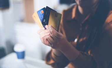 Çevrimiçi ödeme, kredi kartı tutan ve online alışveriş için akıllı telefon kullanan kadının elleri.