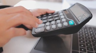 Hesap makinesi ve yazma notu kullanarak mali işler yapan işadamlarının ellerini kapat..