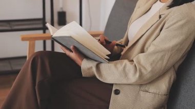 Yemek yemek. Gülümseyen, uzaktan kumandalı genç bir kız öğrencinin dizüstü bilgisayar eğitimi dersine yakından bakın. Kağıt çalışma kitabına elle not alın. Milenyum hanımı uzak eğitim aldı. İnternetten ders tezi yazdı.