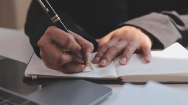 Yemek yemek. Gülümseyen, uzaktan kumandalı genç bir kız öğrencinin dizüstü bilgisayar eğitimi dersine yakından bakın. Kağıt çalışma kitabına elle not alın. Milenyum hanımı uzak eğitim aldı. İnternetten ders tezi yazdı.