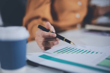 Business woman using calculator to calculate financial report, working at office with laptop computer on table. Asian female accountant or banker making calculations. finances and economy concept