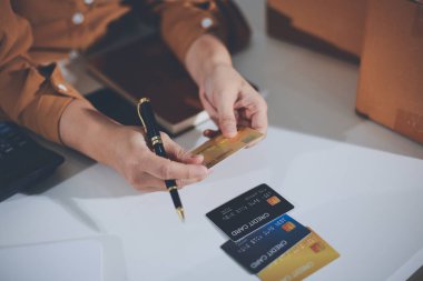 Çevrimiçi ödeme, kredi kartı tutan ve online alışveriş için akıllı telefon kullanan kadının elleri.