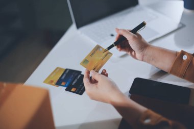 Çevrimiçi ödeme, kredi kartı tutan ve online alışveriş için akıllı telefon kullanan kadının elleri.