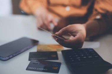 Çevrimiçi ödeme, kredi kartı tutan ve online alışveriş için akıllı telefon kullanan kadının elleri.