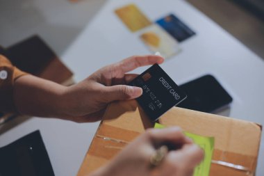 Çevrimiçi ödeme, kredi kartı tutan ve online alışveriş için akıllı telefon kullanan kadının elleri.