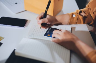 Çevrimiçi ödeme, kredi kartı tutan ve online alışveriş için akıllı telefon kullanan kadının elleri.