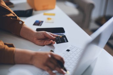 Çevrimiçi ödeme, kredi kartı tutan ve online alışveriş için akıllı telefon kullanan kadının elleri.