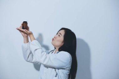 Tedavi için ilaç ya da ilaç tutan doktor ya da eczacı. Şişede antibiyotik hap var..