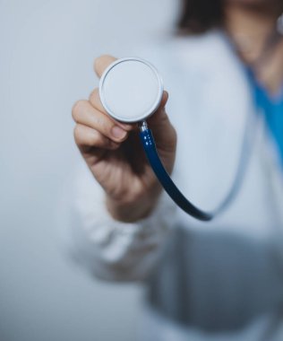 Elinde steteskop tutan genç bir erkek doktor.