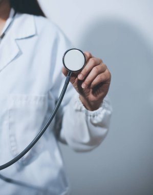 Elinde steteskop tutan genç bir erkek doktor.